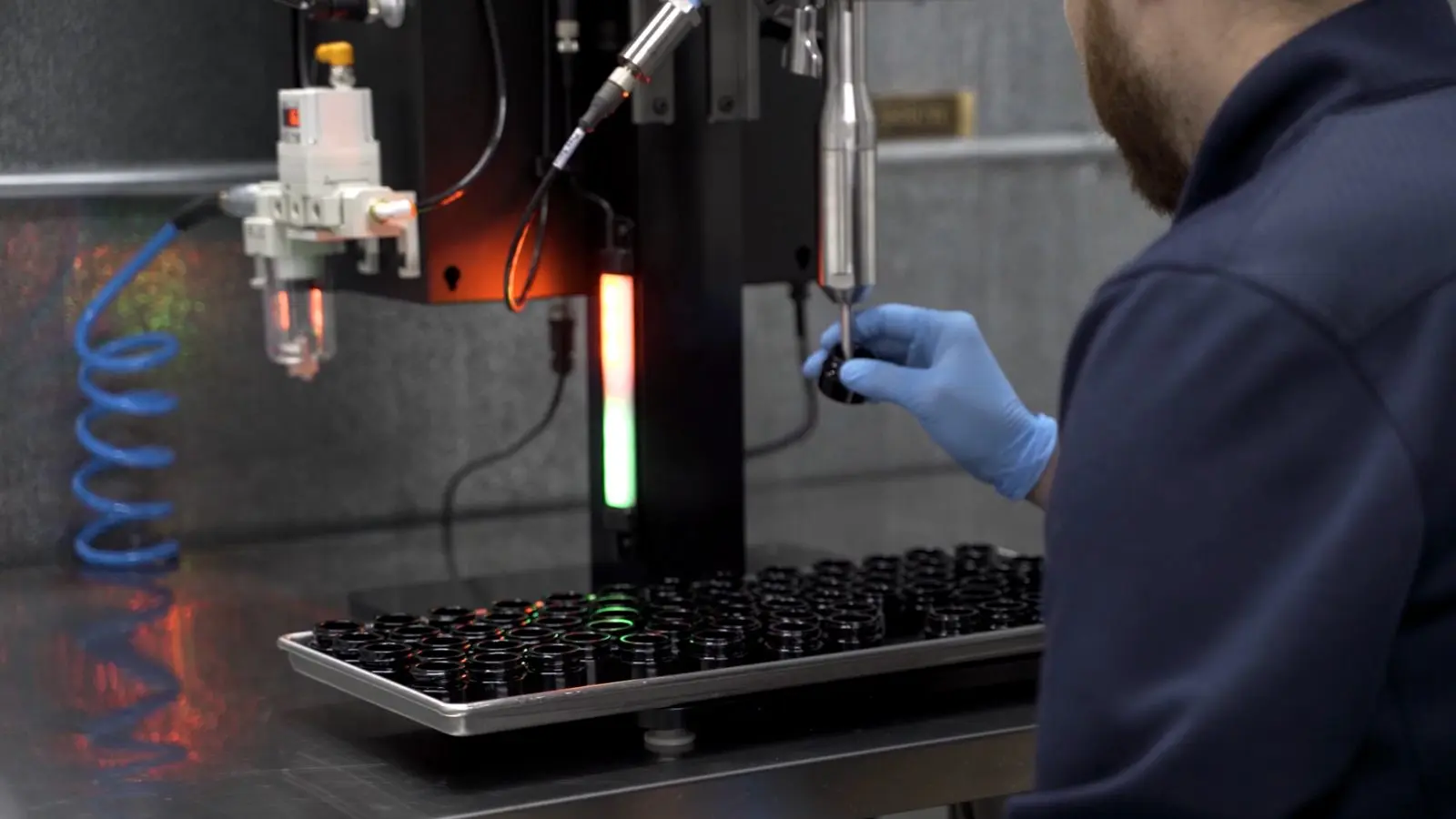 Gloved operator filling cartridges with a dispense valve