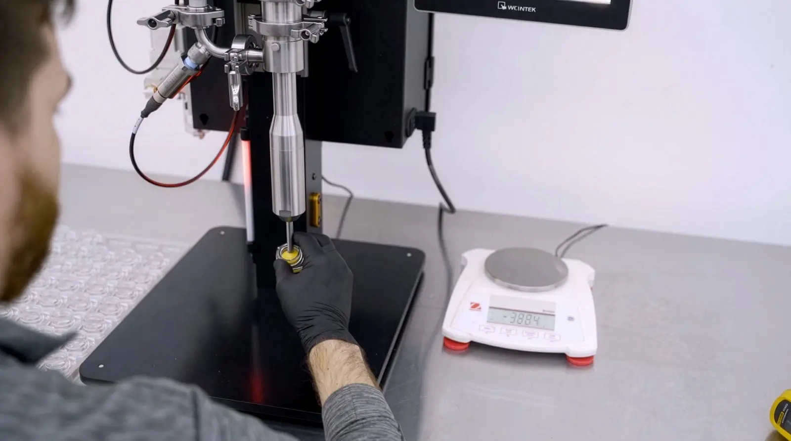 Operator dispensing into a cartridge next to a lab scale
